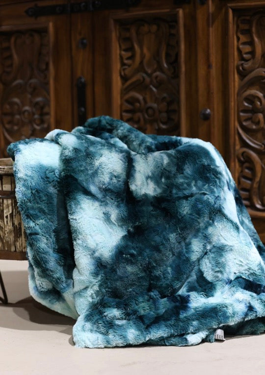 Blue textured blanket on a surface with a wooden background